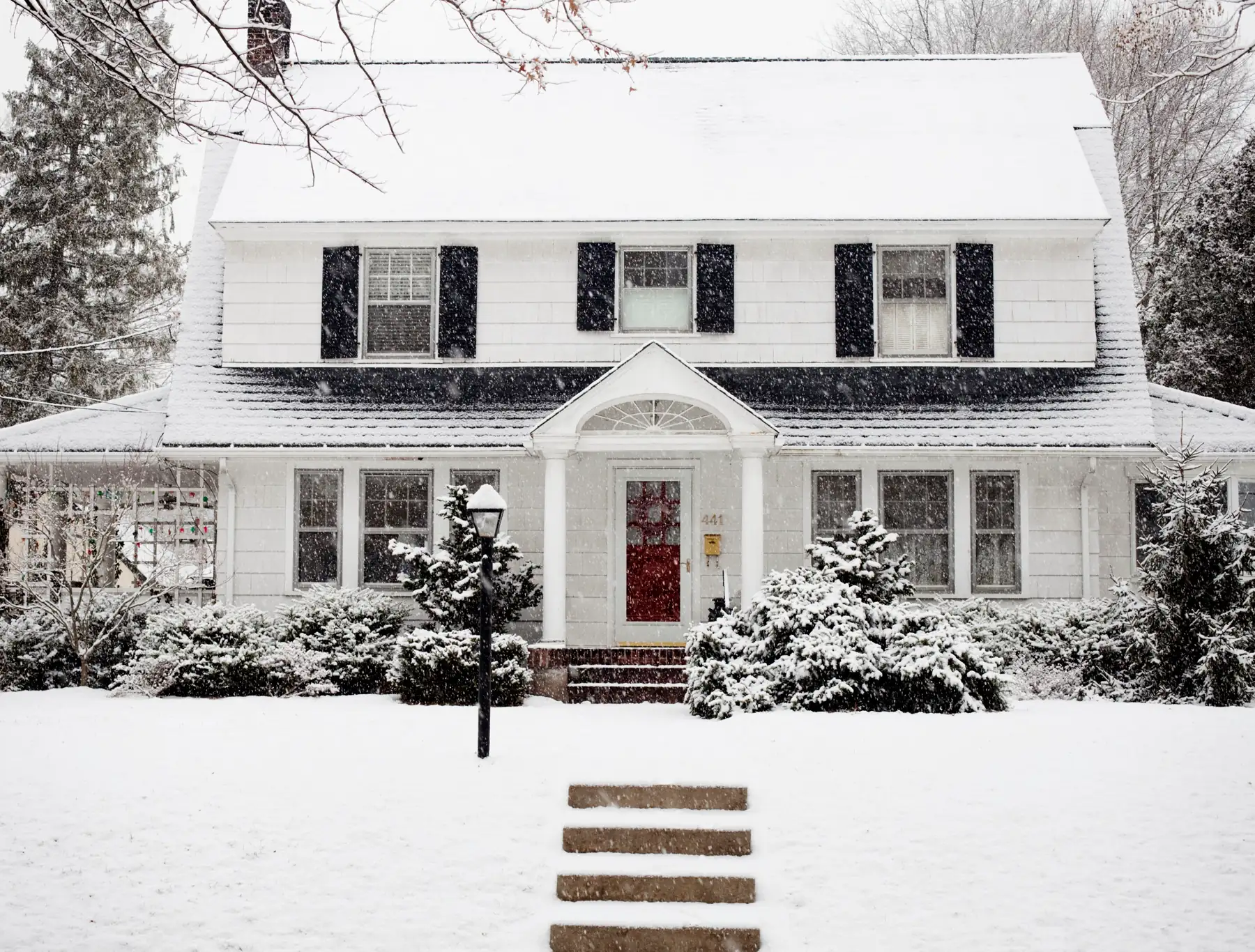 A white colonial home in the snow